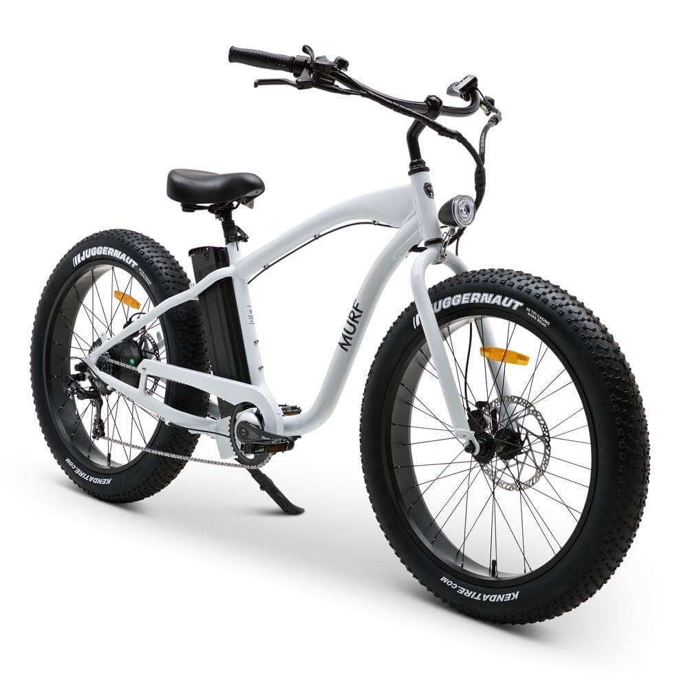 A fat tire electric beach cruiser bicycle with hydraulic disk brakes and a thumb throttle, mounted on large black tires and a classic beach cruiser frame.